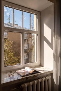uma janela com um livro sobre um radiador num quarto em Beautiful Designer Apartment in Riga center em Riga