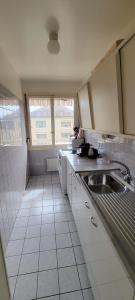 een witte keuken met een wastafel en een raam bij 321 Perfectly situated in Ouchy near IMD in Lausanne