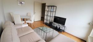 een woonkamer met een bank, een tv en een tafel bij 321 Perfectly situated in Ouchy near IMD in Lausanne