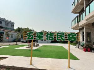a group of signs in front of a building at 五星佶民宿 in Jinning