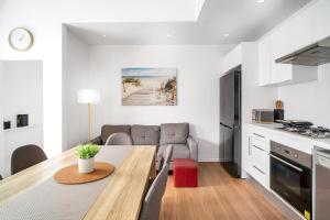 uma cozinha e sala de estar com uma mesa e um sofá em Balmain Beauty - Spacious Garden em Sidney