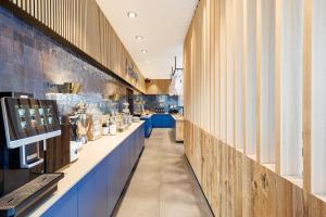 a store with a long aisle with blue counters at ibis Styles Vechta in Vechta