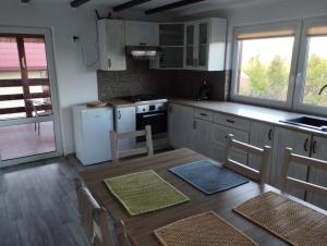 a kitchen with a table and chairs in a room at Pokoje Gościnne "Spokojna 10" 600-065-145 in Polańczyk