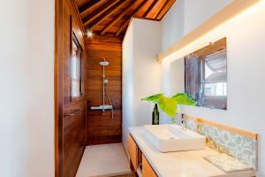 un baño con lavabo y espejo en Mini Villa, en Munggu 3 fotos más