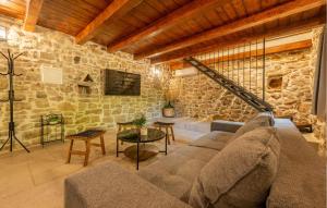 een woonkamer met een bank en een stenen muur bij Tonina in Pristeg