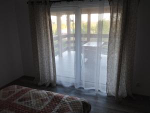 a bedroom with a bed and a sliding glass door at Pokoje Gościnne "Spokojna 10" 600-065-145 in Polańczyk