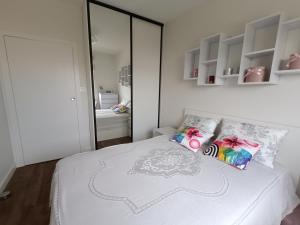 una camera da letto con letto, lenzuola e cuscini bianchi di Apartament Łokietka a Radomsko