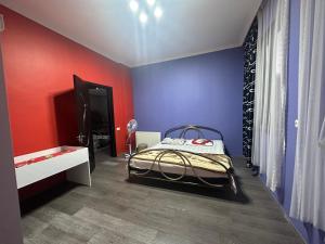 sypialnia z niebieskimi i czerwonymi ścianami oraz łóżkiem w obiekcie Emilis Vacation Home w Kobuleti