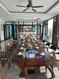 a long wooden table in a room with chairs at King Bavi Resort in Xóm Cầu Rồng