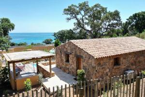 a stone house with a fence in front of it at La Bergerie des Oliviers in Conca