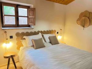 a bedroom with a large white bed and a window at La Bergerie des Oliviers in Conca +12 photos