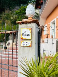 een bord op een hek naast een hek bij Le Maioliche in Saponara Villafranca
