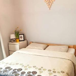 a bedroom with a bed and a nightstand with a bedspread at Kwatera u Somsiada -Apartament in Muszyna