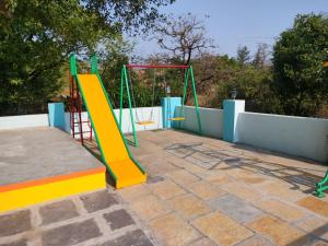 a playground with a slide and a swing at Tapovan Villa & Resort in Pune