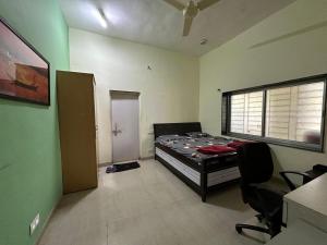 1 dormitorio con 1 cama en una habitación con ventana en Tapovan Villa & Resort, en Pune