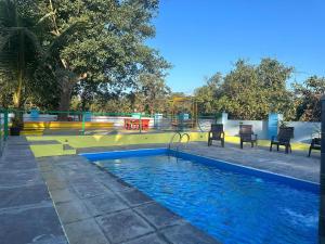 una piscina in un parco con parco giochi di Tapovan Villa & Resort a Pune