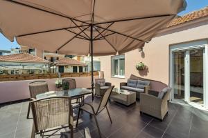 a patio with a table and chairs and an umbrella at Dennis City Center Elegant Apartment (2) in Zakynthos Town