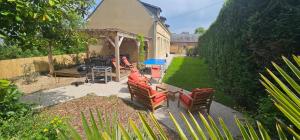 a backyard with chairs and a table and a grill at Le Clos Maldier - Gîte de la Belle vue in Laon