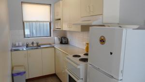 a kitchen with a white refrigerator and a sink at Dunbar Court Unit 4 - 45 Memorial Avenue South West Rocks in South West Rocks