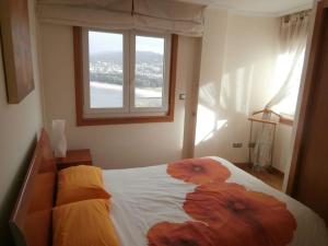 een slaapkamer met een bed met bloemen erop bij Precioso apartamento con excelentes vistas al mar in Puentedeume