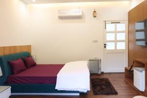 een slaapkamer met een bed en een raam bij FabHotel Prime The Aravali Resort in Rishīkesh