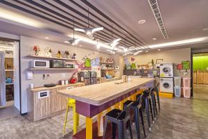 a kitchen with a large island with chairs in it at Backpackers Hostel - Taipei Changchun in Taipei