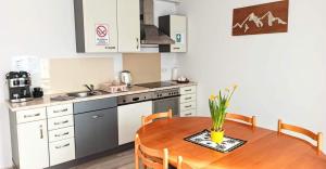 a kitchen with a wooden table and a table and chairs at Kwatera u Somsiada -Apartament in Muszyna