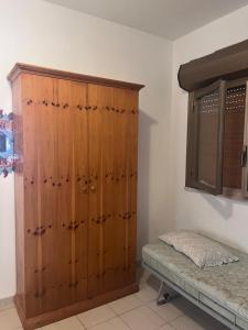 um grande armário de madeira num quarto com uma cama em Boutiqe Residence em Isola delle Femmine
