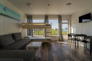 a living room with a couch and a bunk bed at Pučia HUB in Svencelė