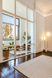 - un salon avec une grande fenêtre et une table dans l'établissement Paris End of St Kilda Apartment, à Melbourne