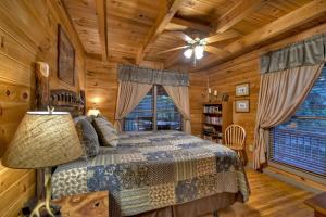 a bedroom with a bed in a log cabin at K6 Lodge Gather around the firepit soak in the hot tub and splash in the creek in Blue Ridge