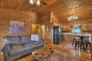 a living room with a couch and a kitchen at Bearfoot Ridge Wood-burning fireplace cozy hot tub serene views in Ellijay