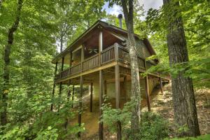 eine Hütte im Wald mit einer umlaufenden Terrasse in der Unterkunft Bearfoot Ridge Wood-burning fireplace cozy hot tub serene views in Ellijay