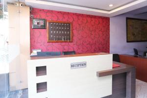 a waiting room with a red wall with acision at OYO Hotel Kanha Palace in Kota