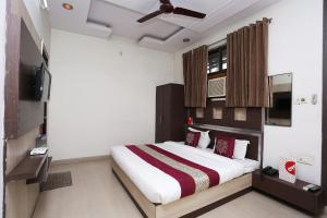 1 dormitorio con 1 cama grande y TV en OYO Hotel Kanha Palace, en Kota