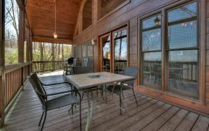 a screened in porch with a table and chairs on it at Appalachian Sunrise Amazing views Close to Blue Ridge hike from the cabin in Blue Ridge
