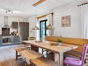 cocina y comedor con mesa de madera y sillas en Stylish holiday apartment in Leogang Salzburgerland near ski area en Leogang