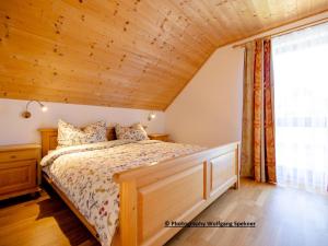 ein Schlafzimmer mit einem Bett mit Holzdecke in der Unterkunft Chalet in Carinthia with Sauna near Ski Slopes in Weinebene