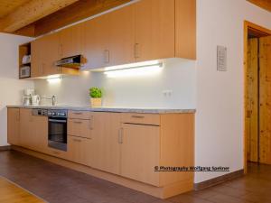 eine Küche mit Holzschränken und einer Arbeitsplatte in der Unterkunft Chalet in Carinthia with Sauna near Ski Slopes in Weinebene + 20 Fotos