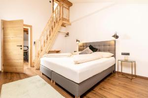 a bedroom with a large white bed with a staircase at Apartment in Strass im Zillertal in a beautiful setting in Strass im Zillertal