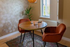 2 Stühle und ein Holztisch in einem Zimmer in der Unterkunft B&B Dijkhuis in Vrouwenpolder