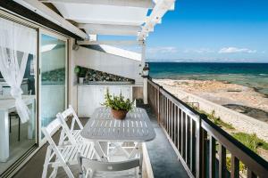 een tafel en stoelen op een balkon met uitzicht op de oceaan bij Casa Cinzia in Marzamemi