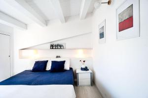 een slaapkamer met een blauw bed en een witte muur bij Casa Cinzia in Marzamemi