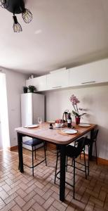 cocina con mesa de madera y 2 sillas en Gite au Petit Verger, en Masevaux