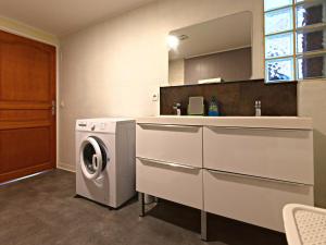 a kitchen with a washing machine and a sink at LE CONCORDE-WIFI-Clim-Parking-3étoiles-OcKeys in Bram