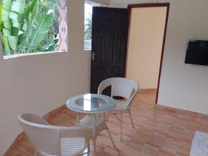 a room with a table and chairs and a door at Precious Holiday Homes Diani beach in Diani Beach