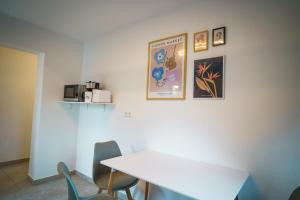 een kamer met een witte tafel en stoelen en foto's aan de muur bij Doppelzimmer 3 - neu renoviert in Dinkelsbühl