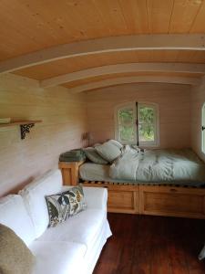een kamer met 2 bedden en een bank in een hut bij Roulotte Karlotte in Pernes-les-Fontaines