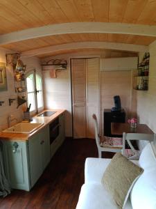 een keuken met een wastafel en een bank in een kamer bij Roulotte Karlotte in Pernes-les-Fontaines