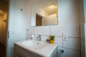 W łazience znajduje się umywalka i lustro. w obiekcie Doppelzimmer 2 - neu renoviert w mieście Dinkelsbühl